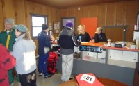 Colleen Millonig, L, with Jenna signs in racers. Note the red Wilderness Athlete bag containing the best looking race shirt I've seen.
