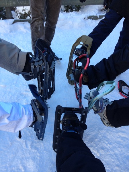 people lifting their leg to hold up their snowshoes