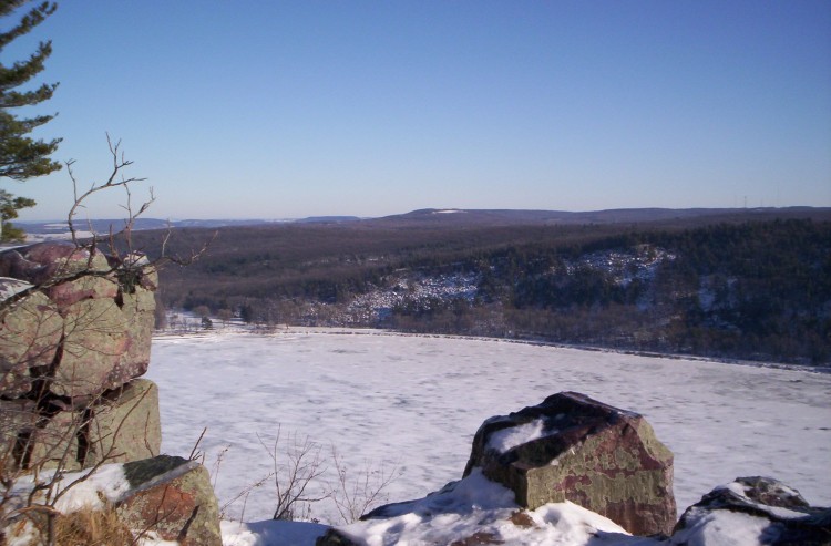 rock cliff overlooking Devil's Lake Wisconsin in winter with blue sky in background