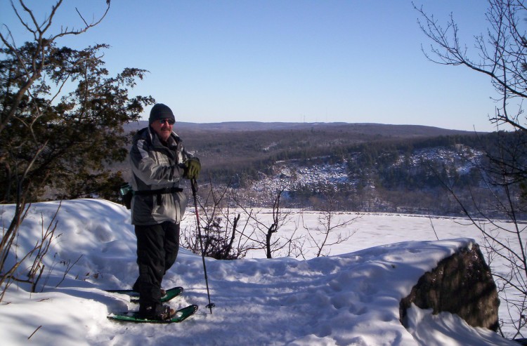 man on snowshoes overlooking Devil's Lake in winter