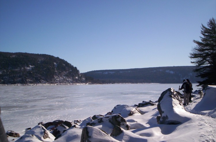 overlook of icy lake with two men off to the side near rock formations