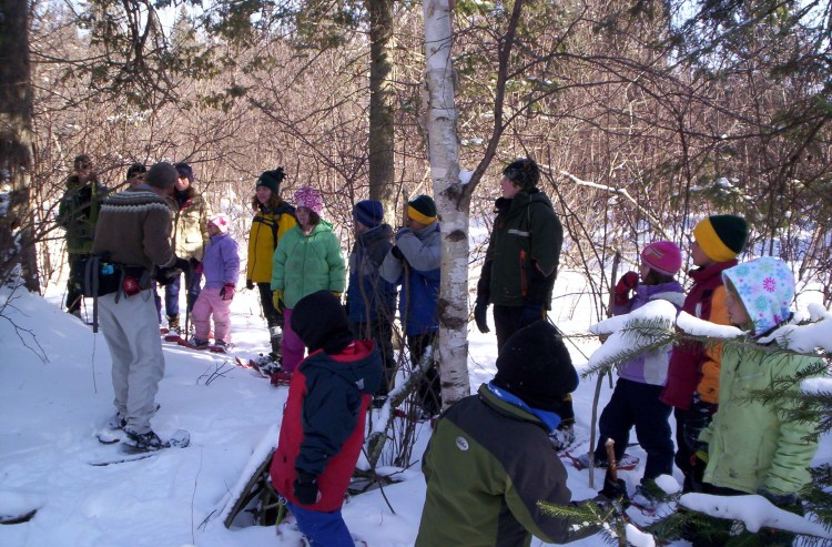 snowshoeing with friends: group of people standing in group on snowshoes in woods