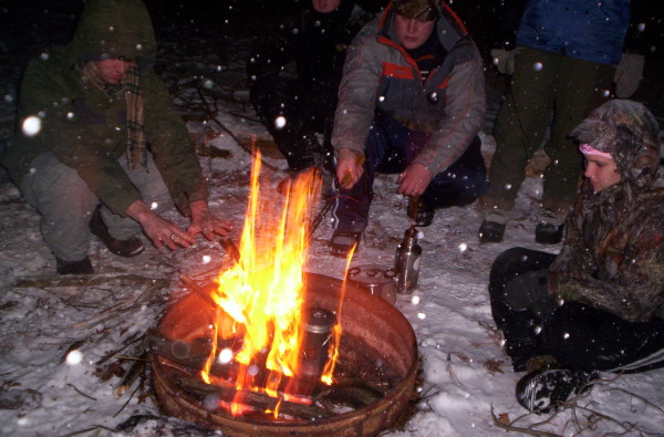 people sitting around a campfire in winter