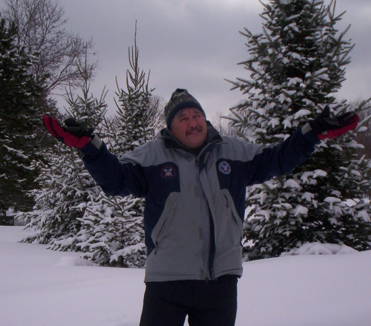 man on snowshoes with arms raised in a "why not" position