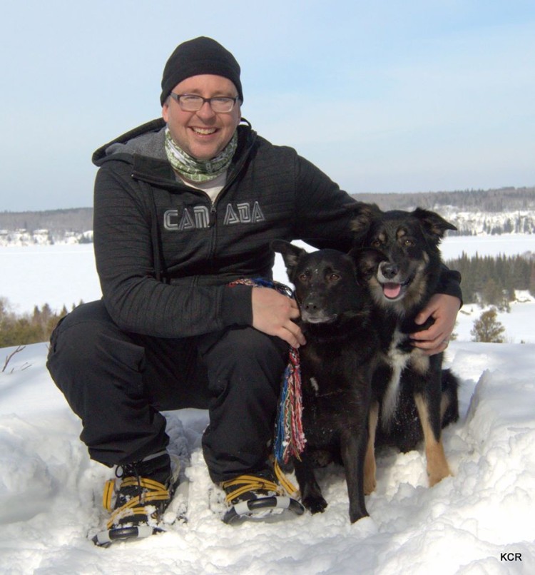 man on snowshoes and dogs posing in snow