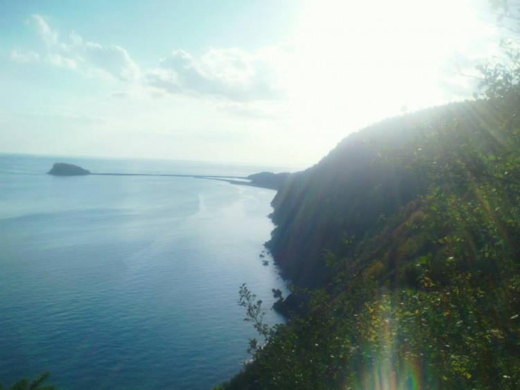 sun shining off the sea cliffs with water in background