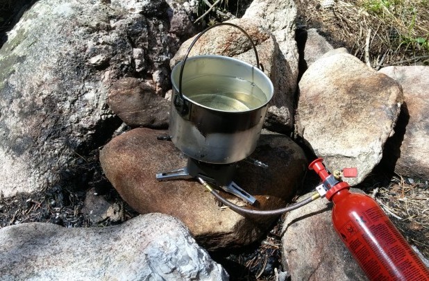 MSR XGK EX stove over a fire pit in warm weather