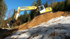 Snow farming. Snow is buried from the previous season in a hole in the forest then covered by wood-chips. Photo credit: Olympiaregion Seefeld.