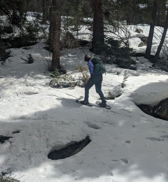 woman snowshoeing with MSR Lightning Ascents up a hill