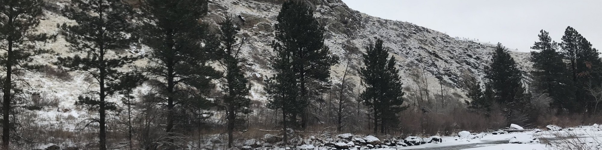 snow, river, and hill in background