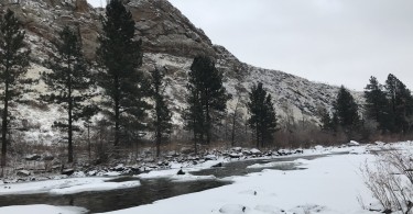 snow, river, and hill in background