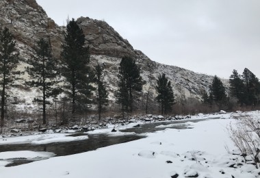 snow, river, and hill in background