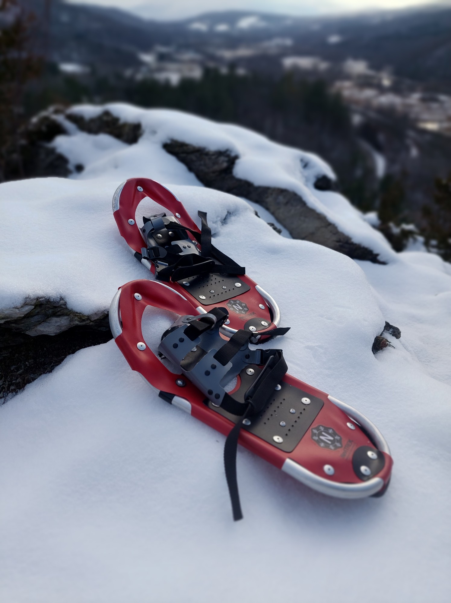 NeviTREK snowshoes on snow with mountains in background