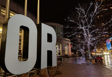 OR sign in front of building with tree lights near street