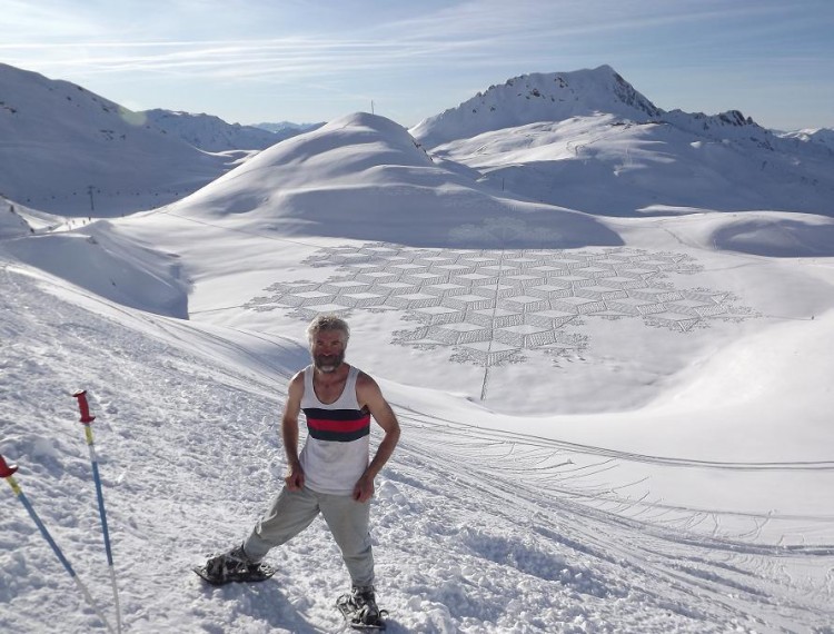 man standing on hill in snowshoes with geometric art in background