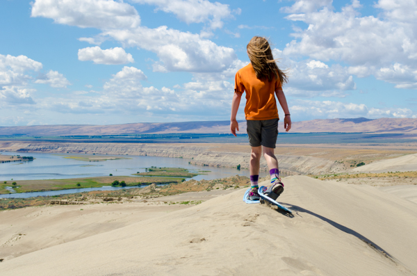 snowshoeing in summer: girl using snowshoes on top of a dune