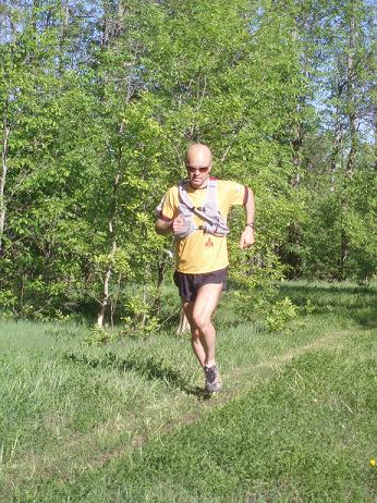 Derrick Spafford trail running with hydration pack during the summer