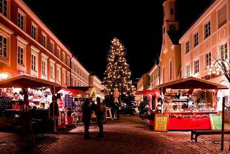 German Christmas market with buildings on sides and tree in background