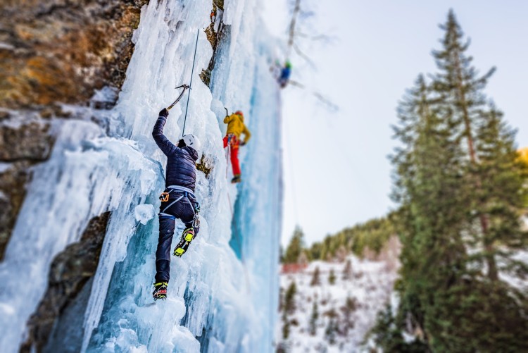Ice climbers scaling frozen cliff