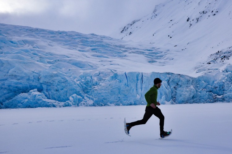 man running on snowshoes in snowy landscape