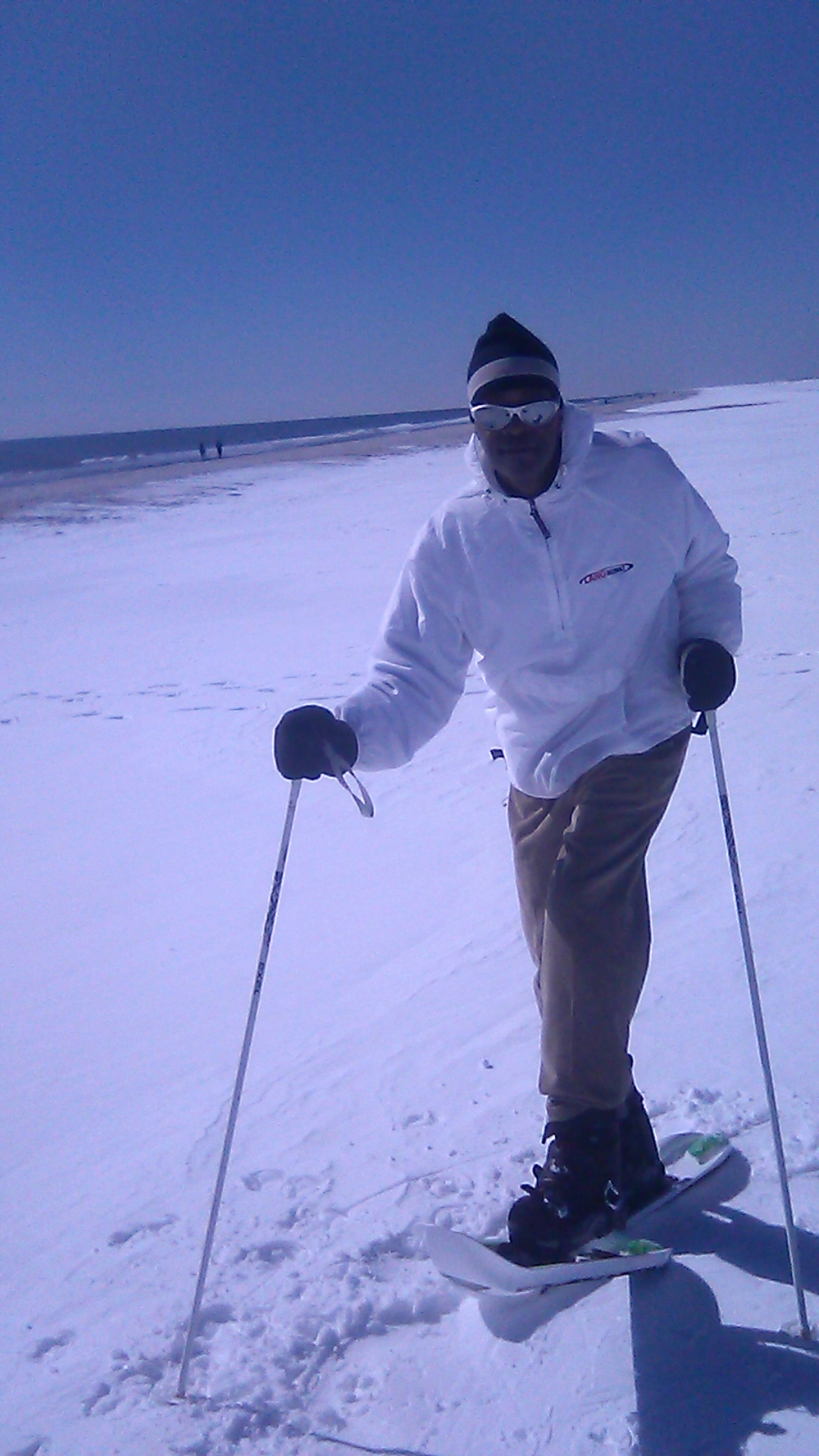 man on Crossblades with poles on snow near Atlantic Ocean