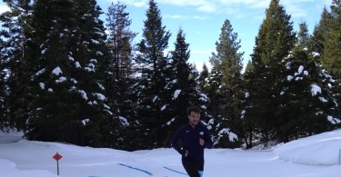 snowshoe racer in front of trees under blue sky