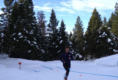 snowshoe racer in front of trees under blue sky