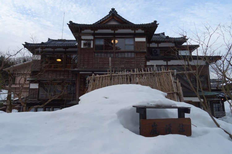 Japanese-style inn with mounds of snow in foreground