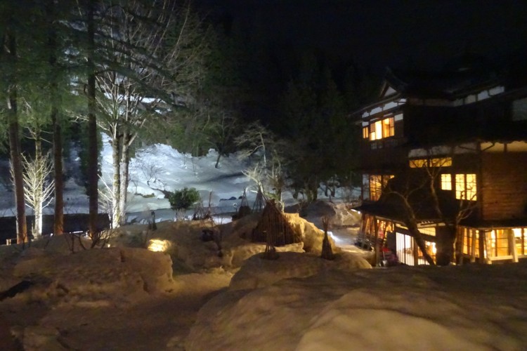 Japanese Inn with candles in snow lighting the walkways