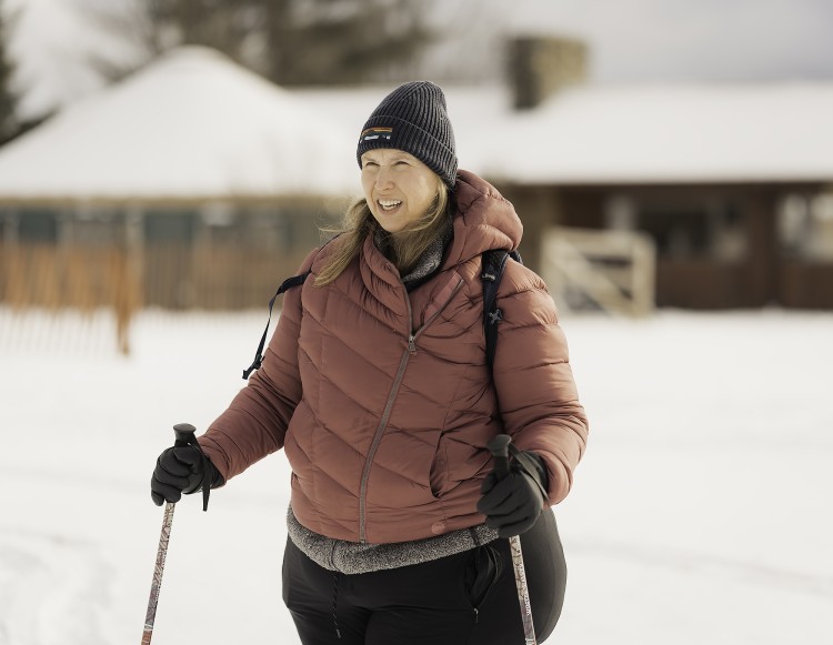 woman snowshoeing with buildings in background
