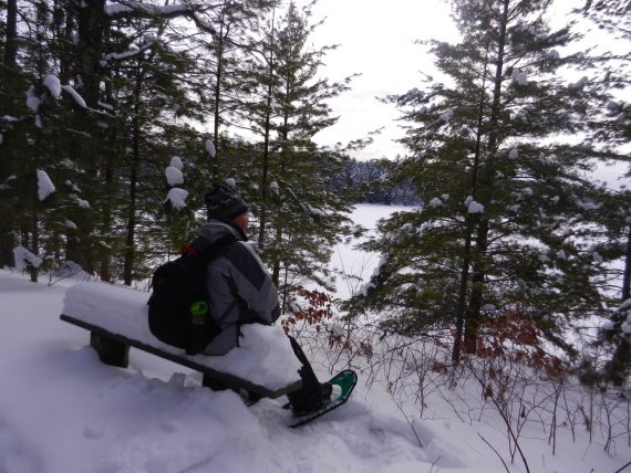 outdoor journaling: man resting on a bench overlooking a lake