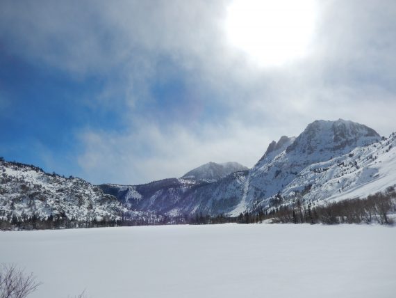 open area, mountains in background, sun high in sky