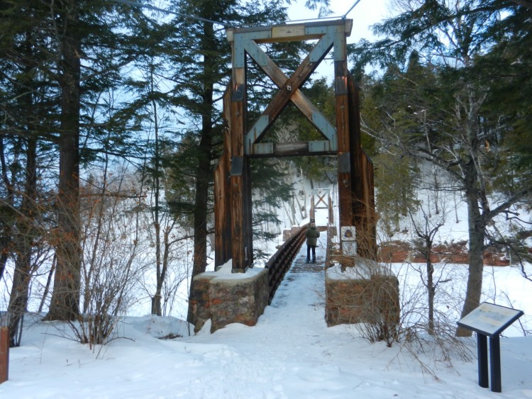 Man standing on bridge in snow