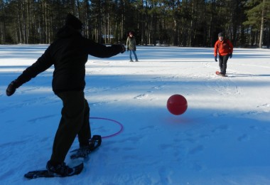 person on snowshoes ready to kick a ball in winter snowshoe game