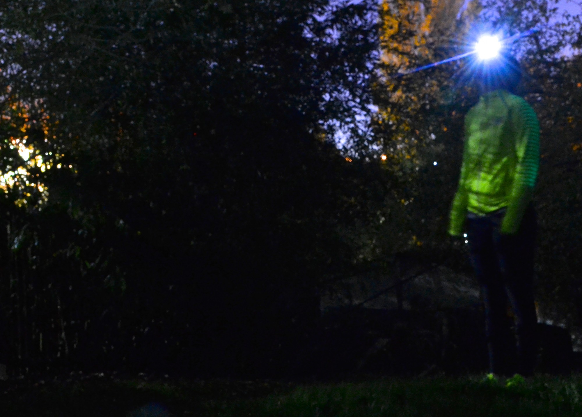 runner wearing bright clothes and headlamp at night