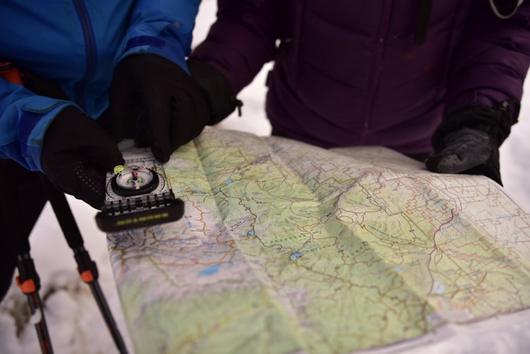 two people using compass on a map