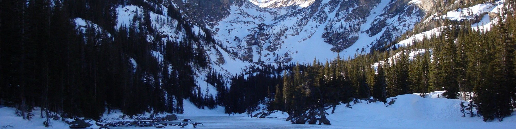 lake covered with snow and mountains in background