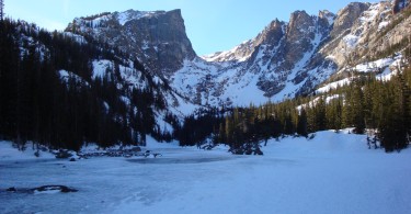 lake covered with snow and mountains in background