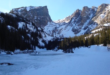 lake covered with snow and mountains in background