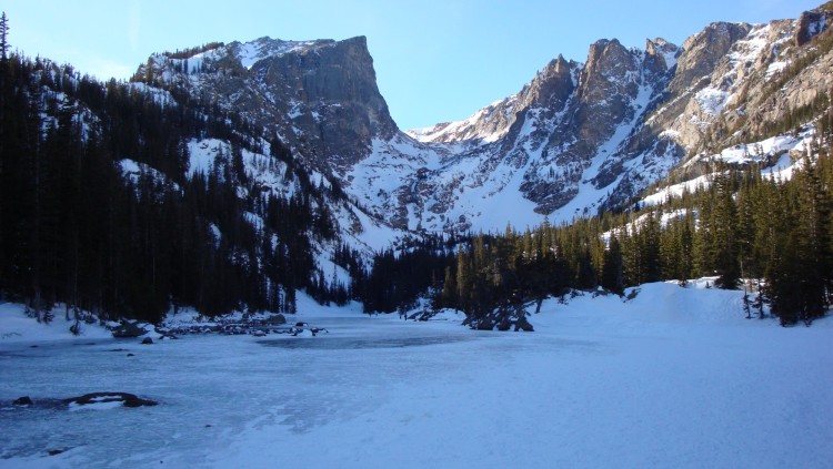 lake covered with snow and mountains in background