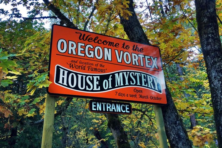 sign for the House of Mystery with trees in background