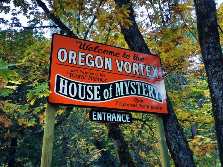 Oregon Vortex: sign for the House of Mystery with trees in background