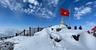 snowy mountain top with railing and blue ski in background