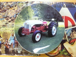 See if you can identify the album covers (or the musicians pictured) as background for the intriguing Ford Tractor plate.