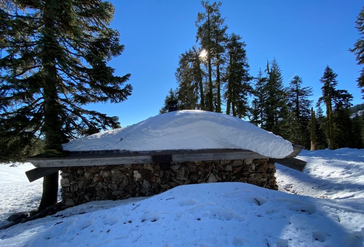 shelter covered in snow with blue sky above