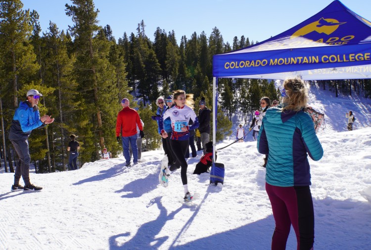 high school girl about to cross finish line at snowshoe race