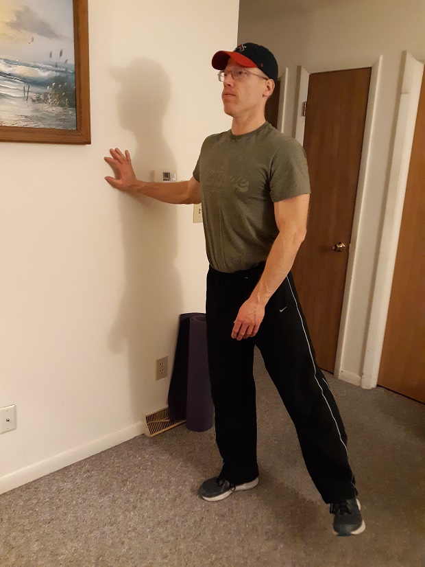 man standing and demonstrating standing hip abduction exercise