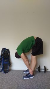 demo of standing forward bend: stretches for snowshoeing