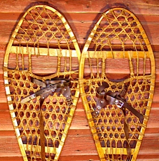 Huron wooden snowshoes laid on wood surface