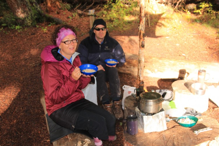 people setting and eating while fall camping